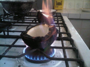Roasting the halves of a dried coconut.